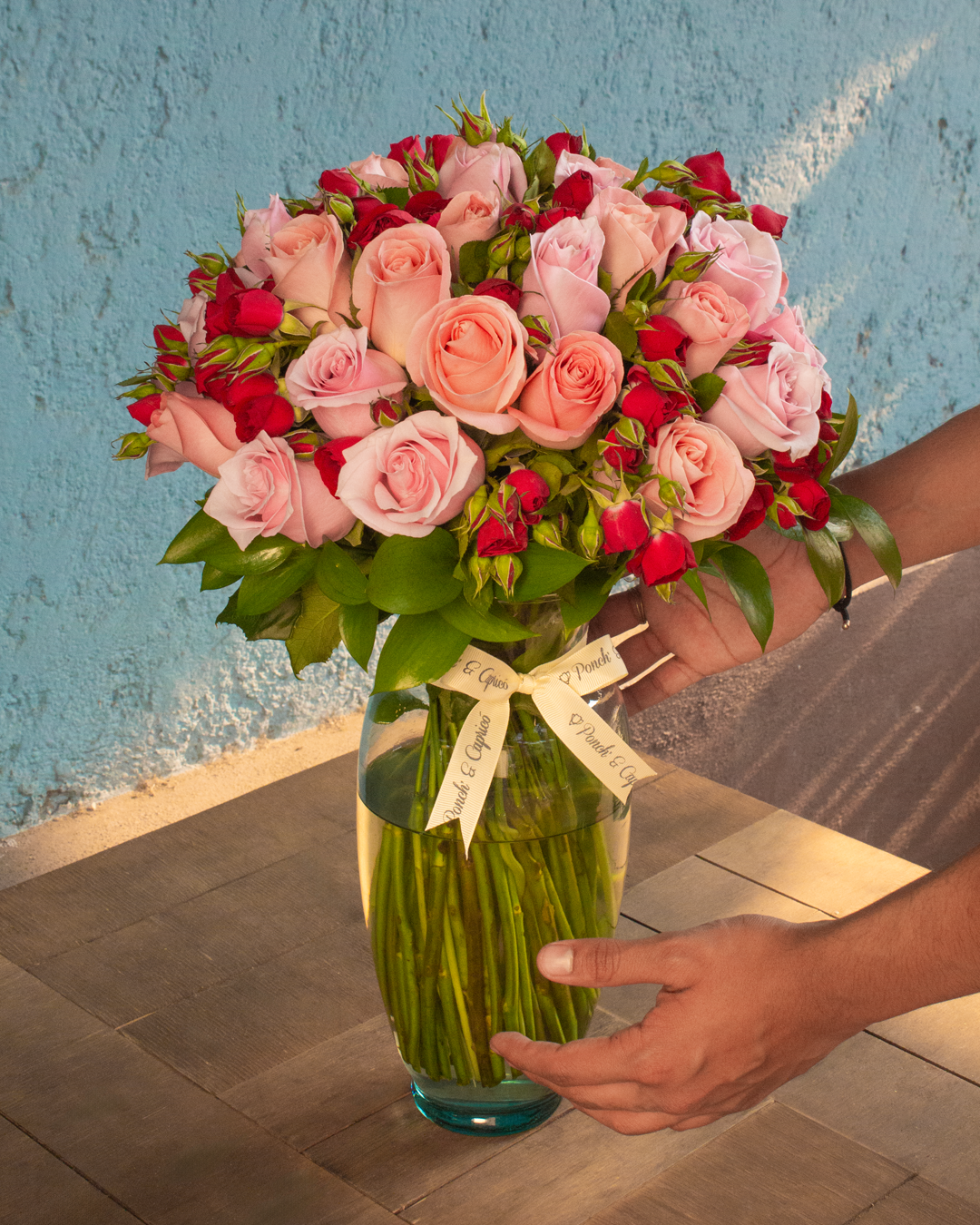 Floral arrangement of pink, nautical and mini roses red roses
