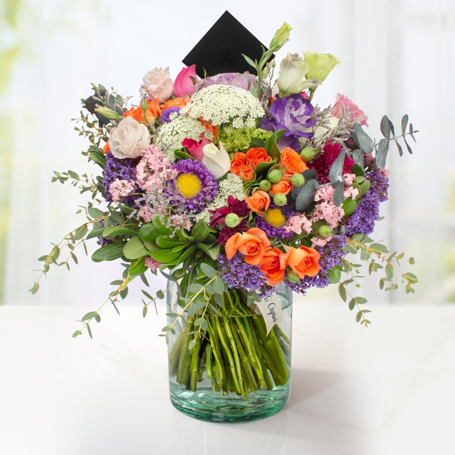 Arreglo floral de Rosas Blancas, Rosas Fucsia, Lisianthus Pecoté Morado, Mini Rosa Naranja y Dólar Verde Preservado -GI021-