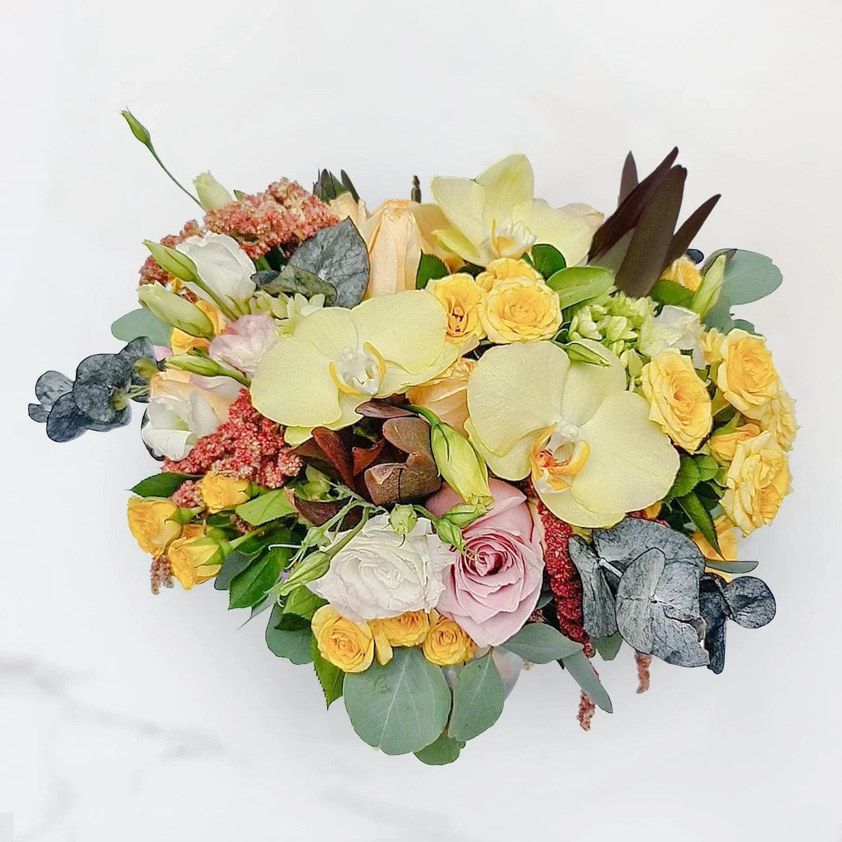 Arreglo floral de Orquídea Amarilla, Rosas Náuticas, Rosas Peach Avalanche, Lisianthus Pecoté Rosado y Dólar Marrón Pres